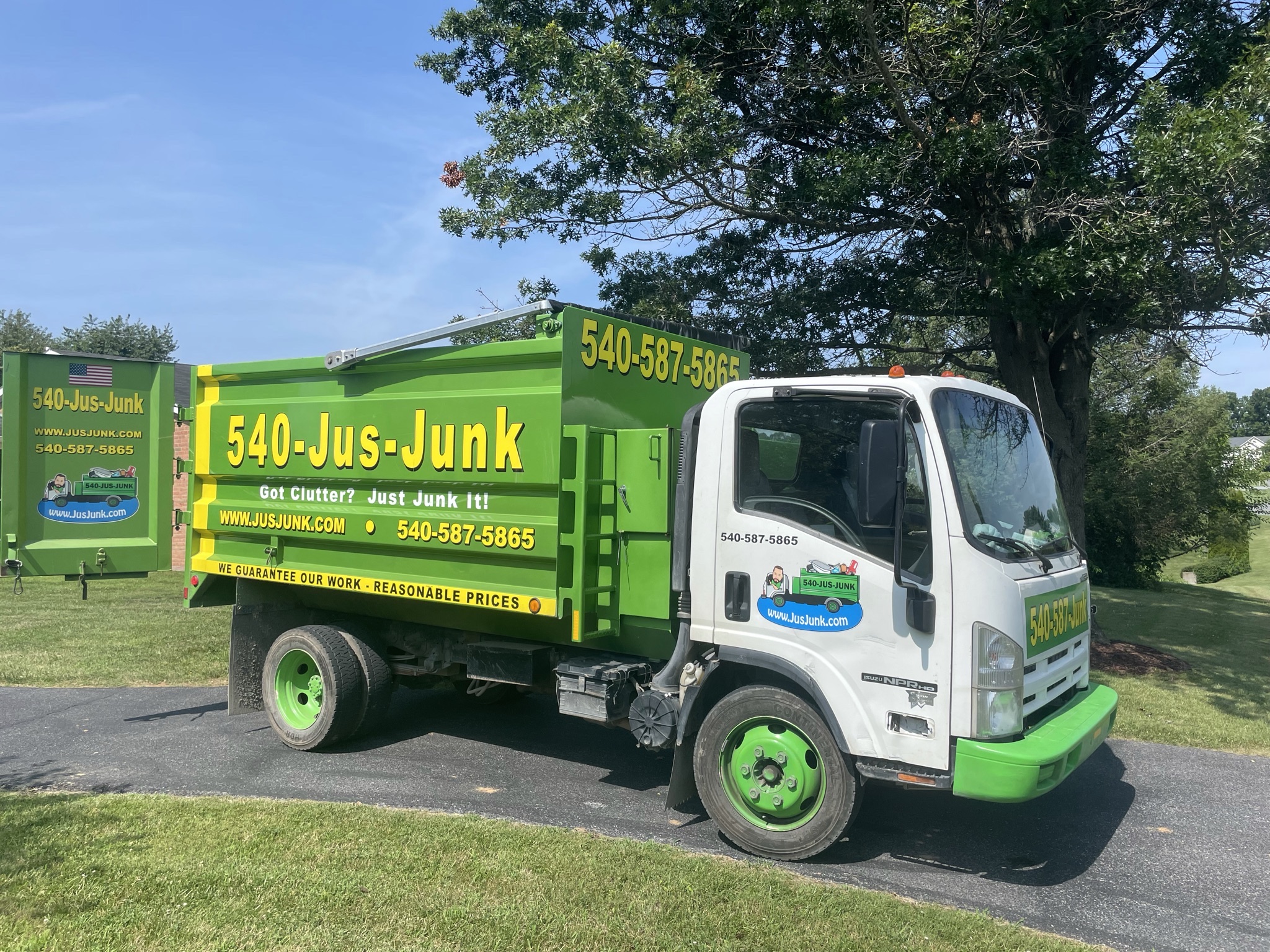 Jus Junk truck in a tree-lined driveway